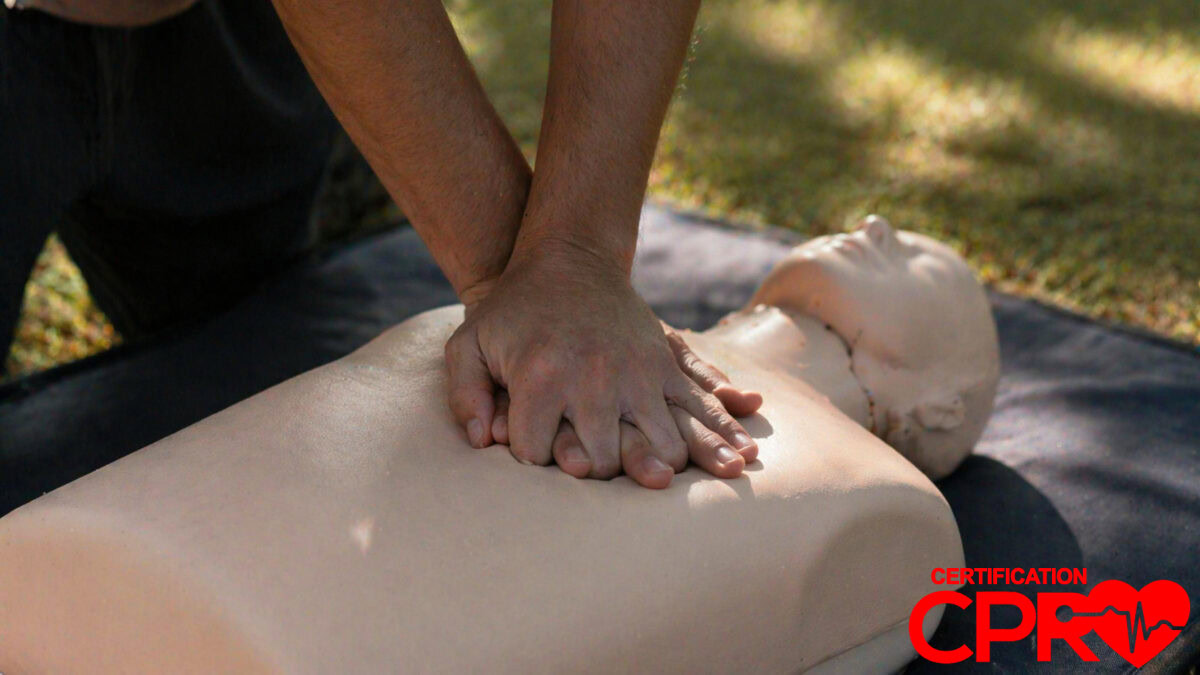 Person performing hands-only CPR on a mannequin outdoors in Austin.